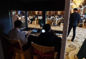 Translators work in a booth as delegates listen to speeches during the opening session of the Belt and Road Forum on Legal Cooperation in Beijing on July 2.