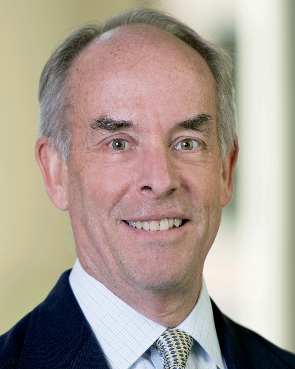 A headshot of Lee Rainie wearing a black suit. Rainie has pale skin and short gray hair. He faces the viewer and smiles.