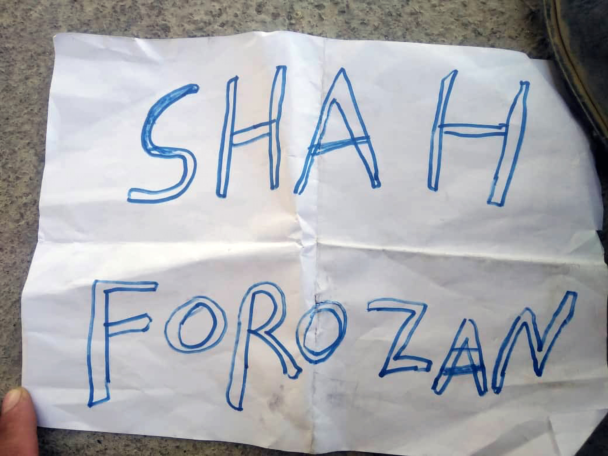 A white page that reads Shah Forozon handwritten in blue ink.