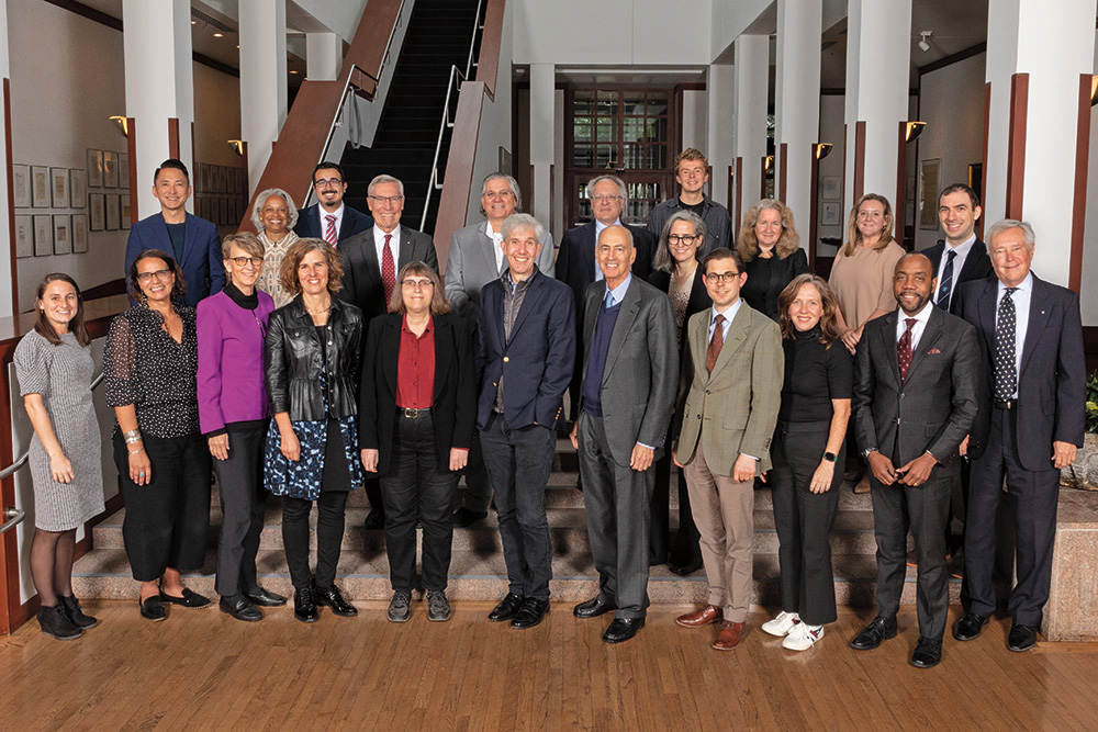 A group of people, dressed professionally, stand together and smiling. 