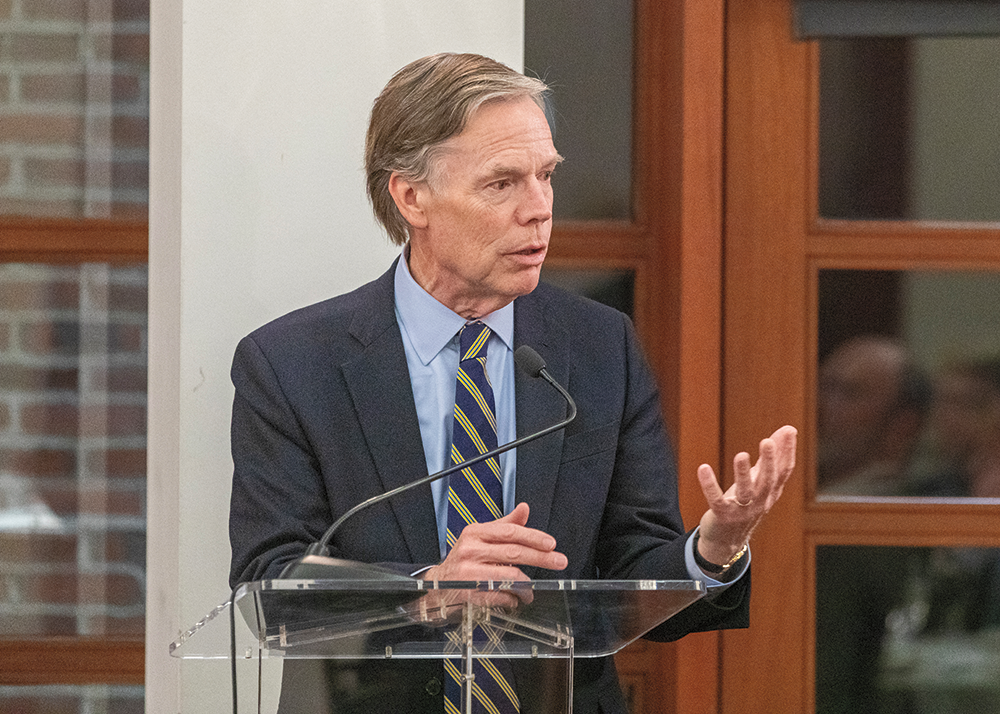 A man in a suit and tie is giving a speech at a podium.