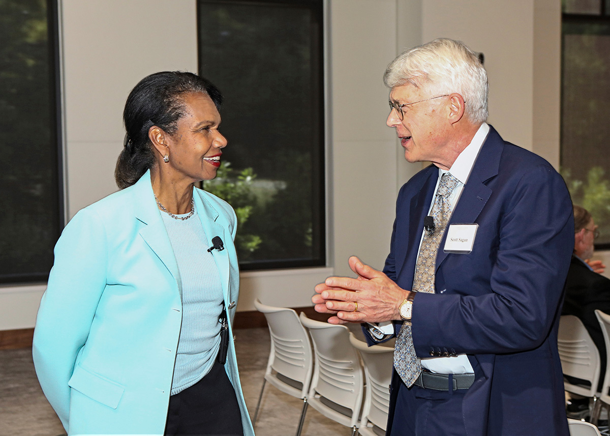 Two formally dressed people speak at a reception.