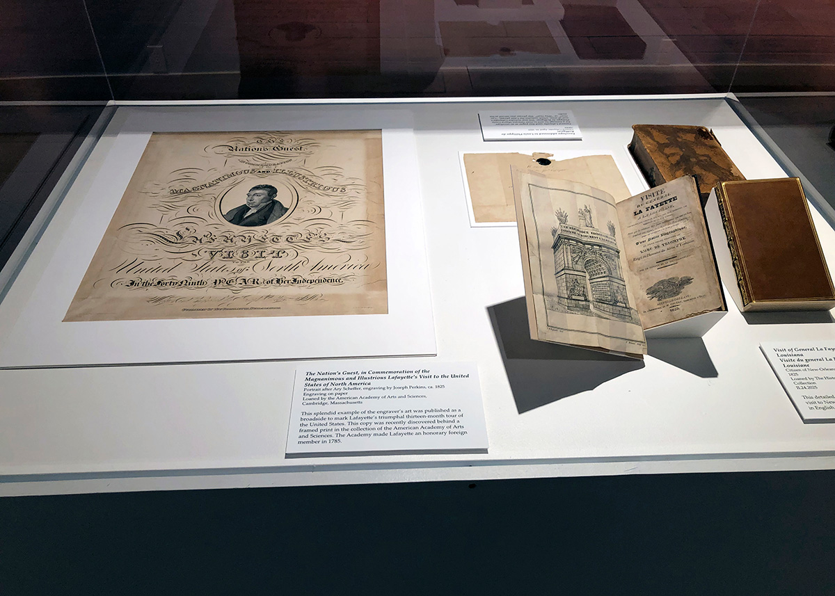 By Michele Lavoie, Director of Archives  Close-up image of the Lafayette broadside, matted for display, installed in a display case alongside a printed volume chronicling the Marquis’s tour. Photo courtesy of the Louisi-ana State Museum. An Archives feature published in the Winter 2022 Bulletin recounted the accidental dis-covery of a broadside advertising the Marquis de Lafayette’s 1824–1825 U.S. tour. Previ-ously unknown to Academy staff, the broadside had been found hidden behind another framed engraving