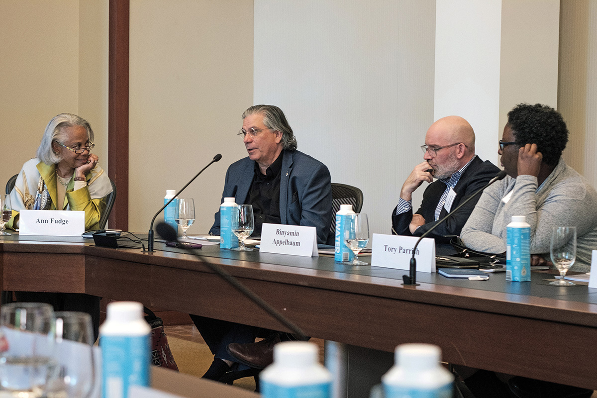 Ann Fudge, Mark Trahant, Binyamin Appelbaum, and Tory Parrish serve as panelists at the Media Roundtable. Mark Trahant faces the audience and speaks into a microphone on the table, while Fudge, Appelbaum, and Parrish face Trahant.