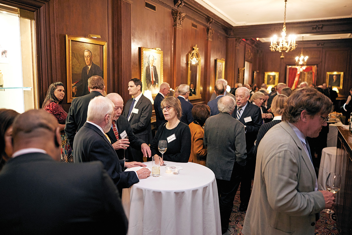 Attendees gather in a dark-paneled room at a formal venue for the launch event in Washington, D.C. to promote Forging Climate Solutions.