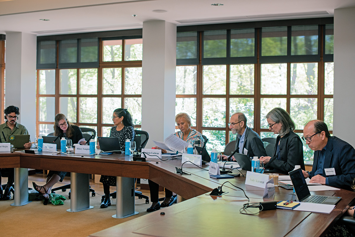 Members from the Commission on Accelerating Climate Action and project staff sit at a conference table with computers and microphones to discuss the project.