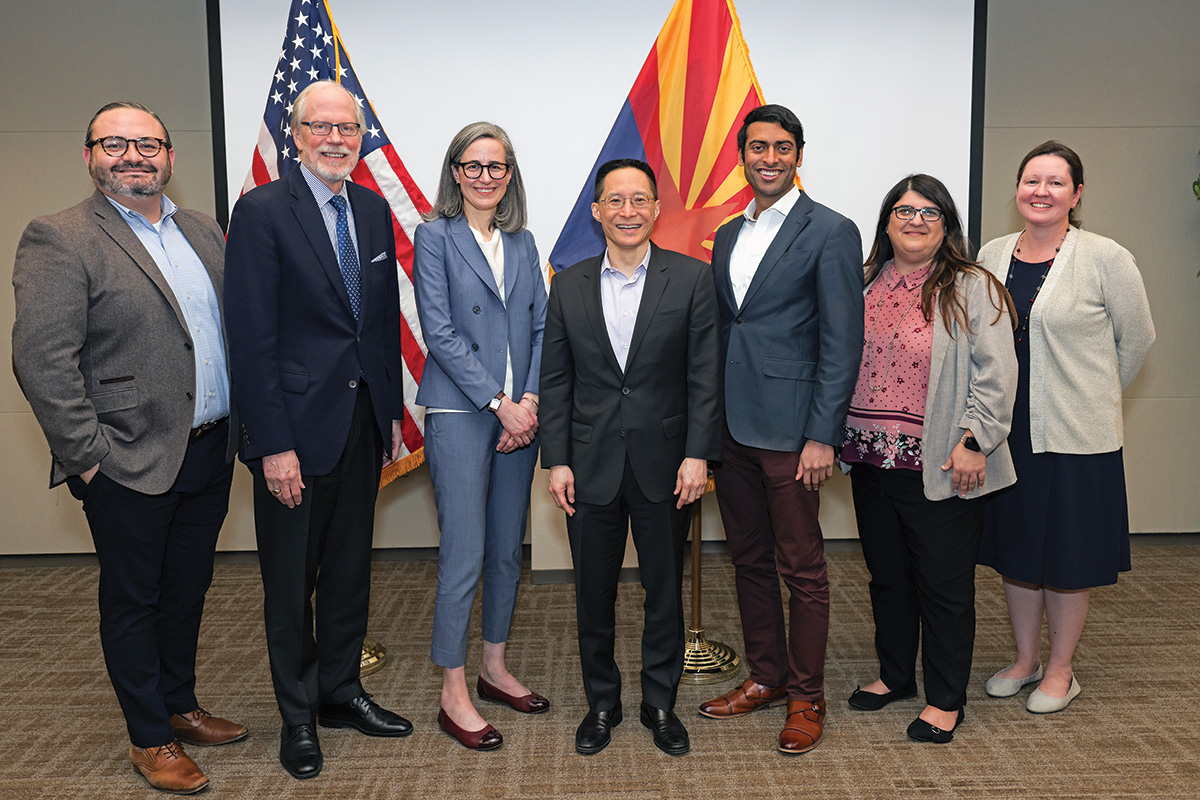 A group of cochairs and Academy staff at the event to promote Our Common Purpose in Phoenix, Arizona stand in front of the Arizona flag and the American flag.