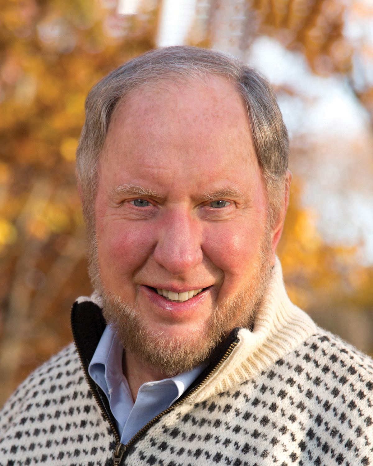A photograph of Robert D. Putnam, a person with pale skin and gray hair. He faces the camera and smiles.