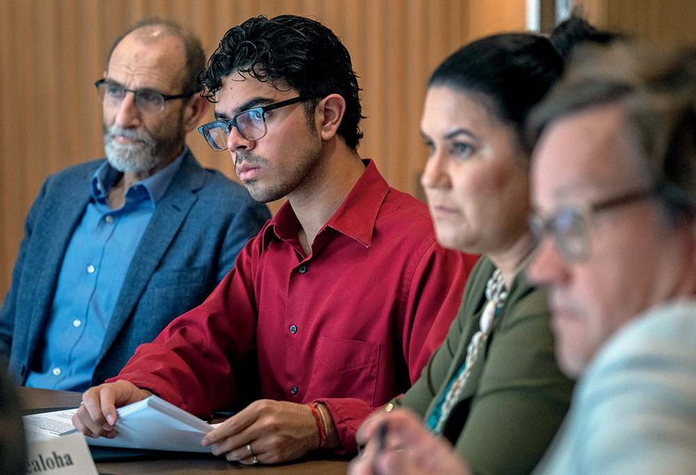 Four members of the Commission on Accelerating Climate Action sit in a row and watch a presentation during the commission’s meeting in Miami. 