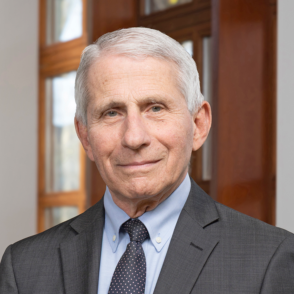A photo of Dr. Anthony Fauci. He has short gray hair and is wearing a dark business suit and tie. He is looking at the viewer. 