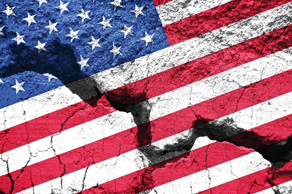 A photograph of an American flag painted on broken pavement. 