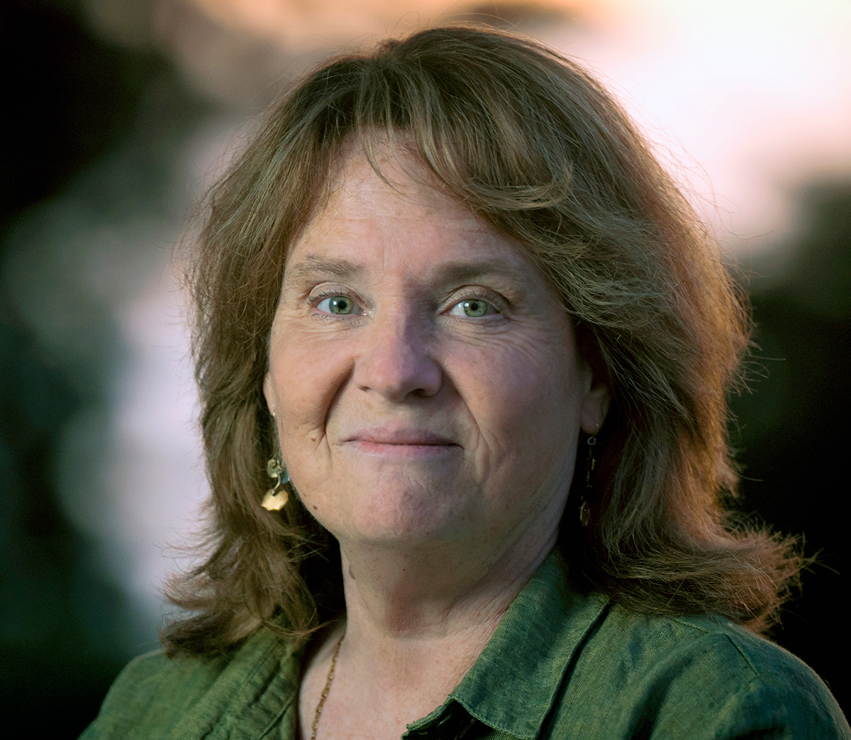 A photo of Kimberly Prather, a light-skinned woman with shoulder length brown hair. She is wearing a green blouse and is smiling at the viewer. 
