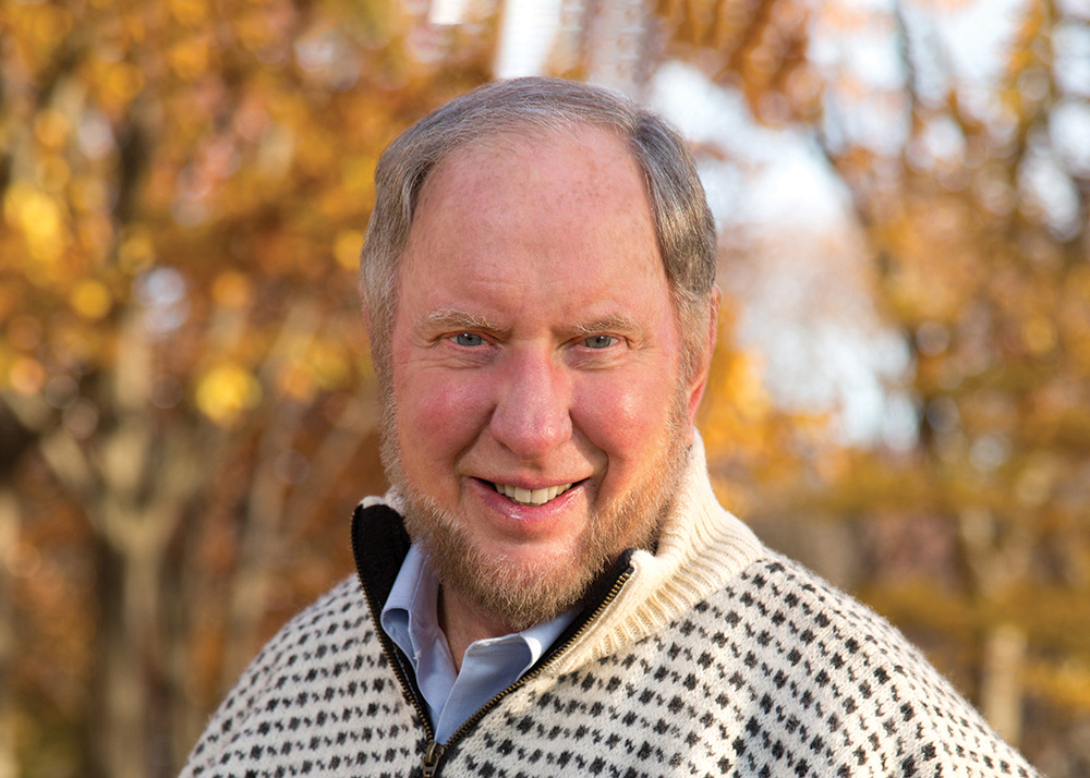 A photograph of Robert D. Putnam, a person with pale skin and gray hair. He faces the camera and smiles.