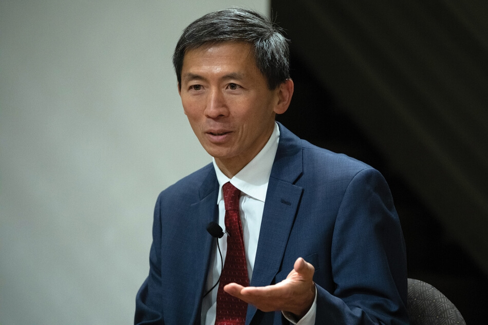 Photo by Martha Stewart Photography. A photo of Associate Justice Goodwin H. Liu, a man with brown skin and short dark hair. He wears a red tie, a white shirt, and a dark blue suit. A microphone is clipped to his tie. Photo by Martha Stewart Photography.