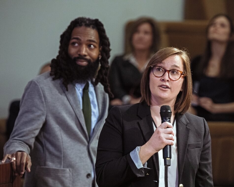 Woman speaking into a microphone with African American male standing next to her. Photo by Martha Stewart Photography.