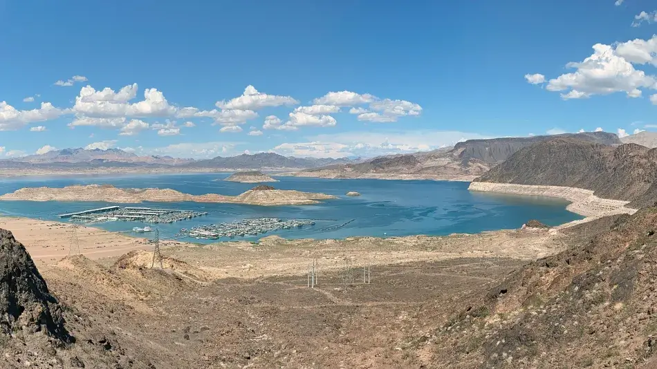 Photo by United States Bureau of Reclamation, Christopher Clark. Published under a Creative Commons Attribution-ShareAlike 2.0 Generic (CC BY-SA 2.0) license. A photo of Lake Mead shows a ring of lighter soil around the lake, marking the higher volume where the water level once reached.