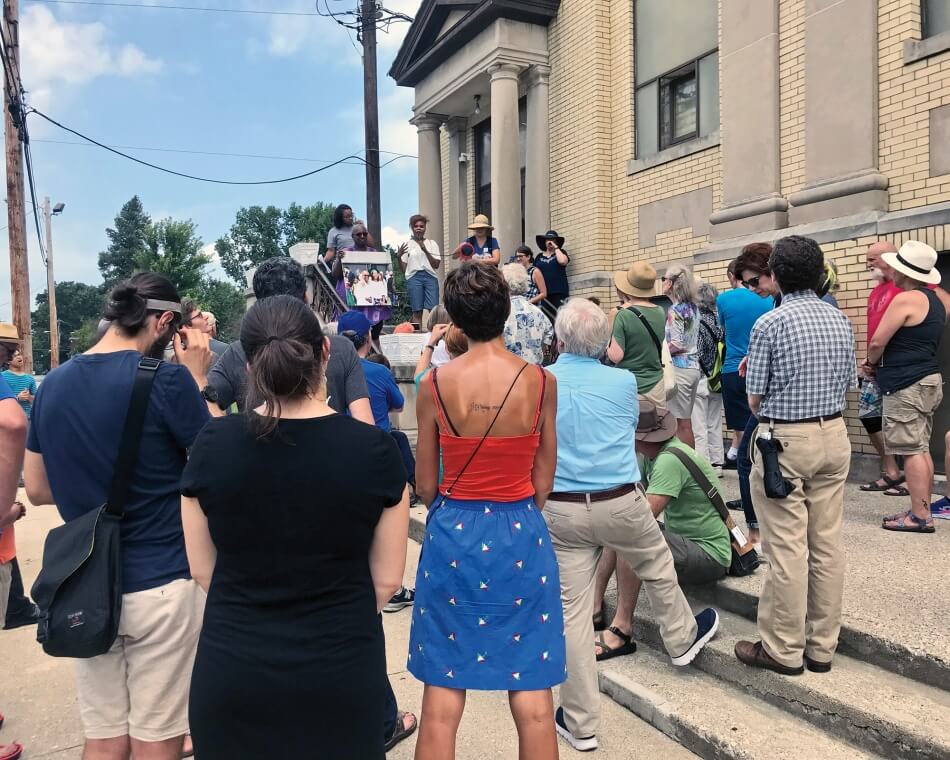 Crowd standing outside listening to a speaker. Photo by Vanessa Grossl.