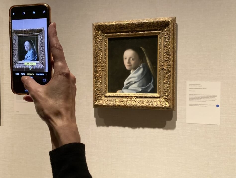 A museum-goer snapping a photo of Johannes Vermeer’s “Study of a Young Woman” (ca. 1665-67) at the Metropolitan Museum of Art in New York (photo by Hakim Bishara for Hyperallergic)