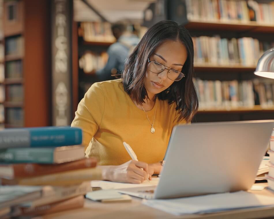 Young lady using a laptop to do research on the internet. Woman working on a project. iStock.com/Marco VDM