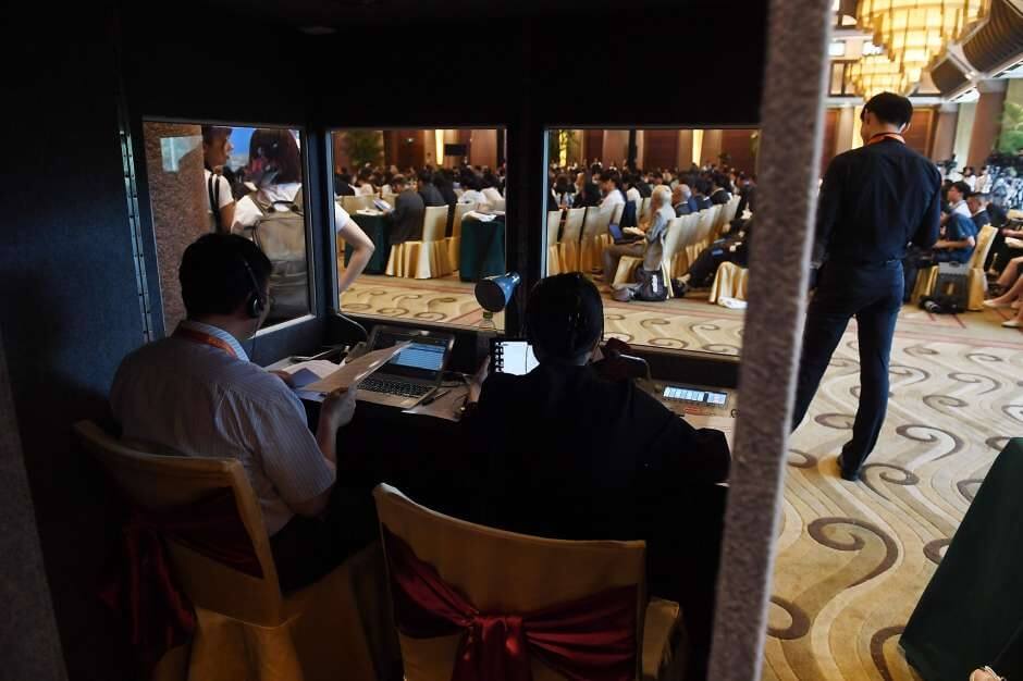 Translators work in a booth as delegates listen to speeches during the opening session of the Belt and Road Forum on Legal Cooperation in Beijing on July 2.