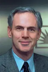 A man wearing a suit and tie is smiling for a picture.