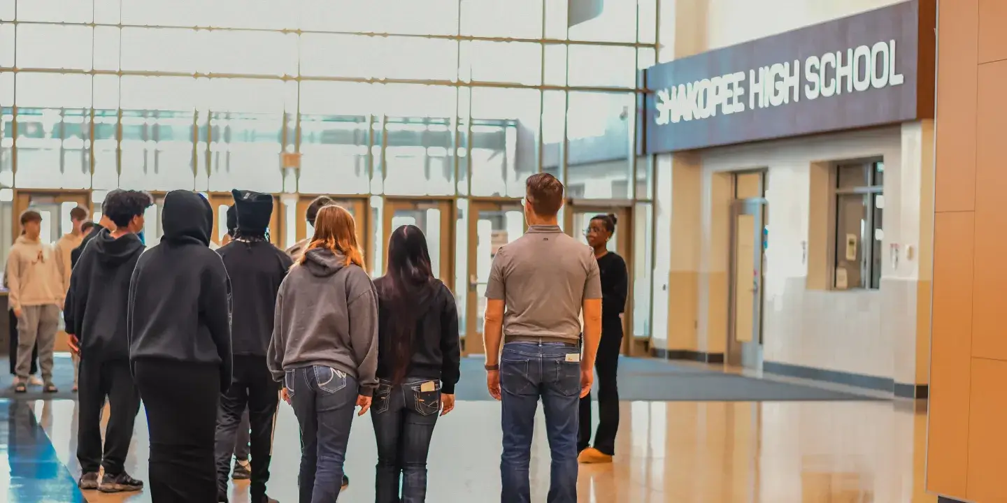 High school students walking in the lobby of their school.