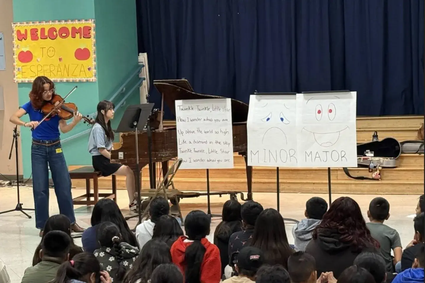 Student musicians perform for an audience of elementary school students.