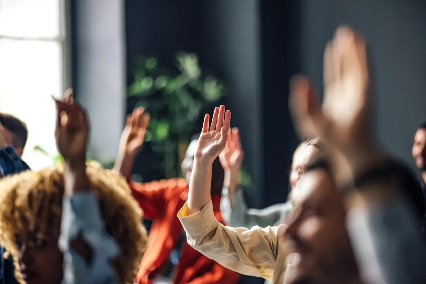 People raising their hands during an event.
