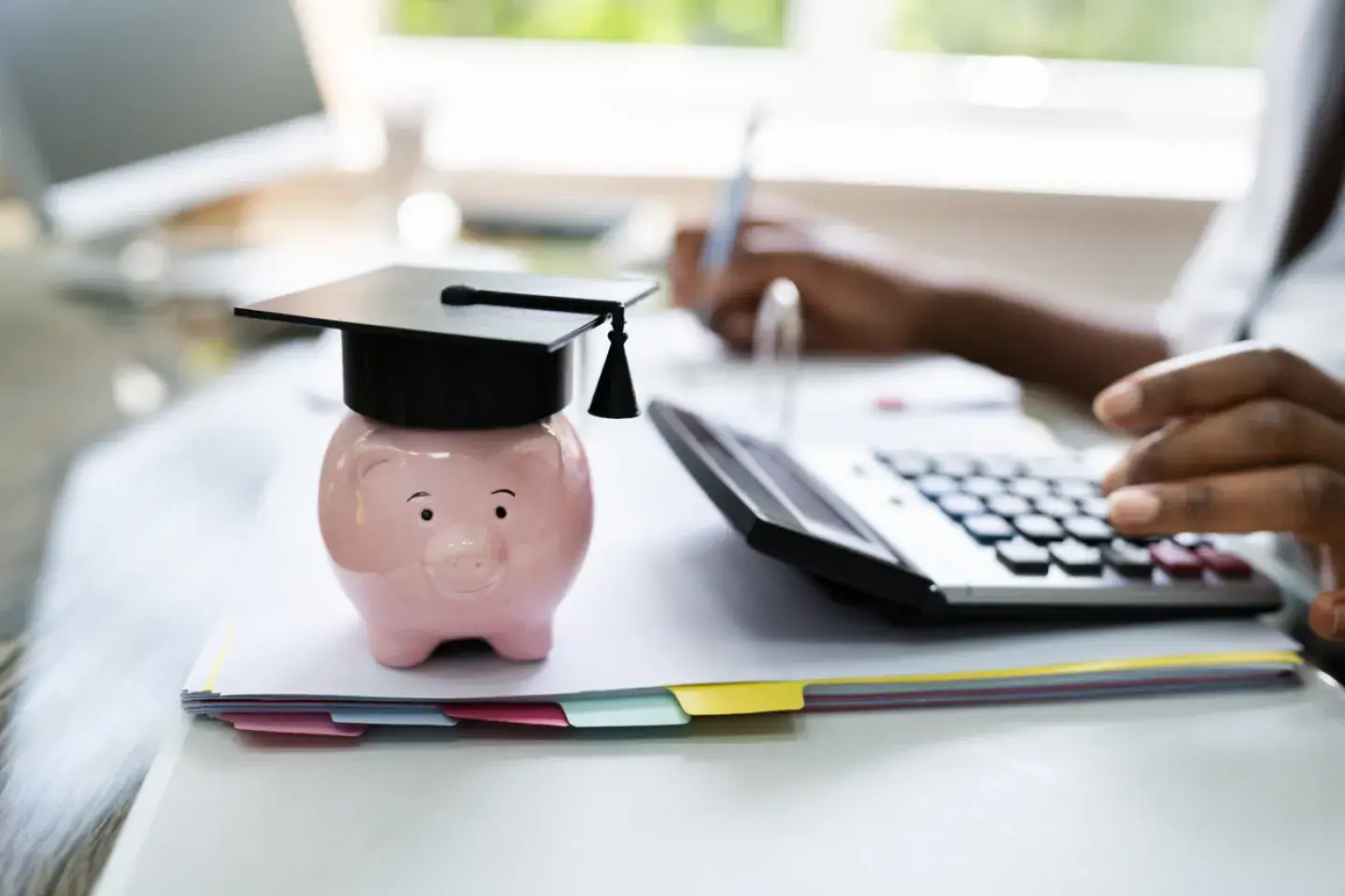 small piggybank with a college graduation cap on it 