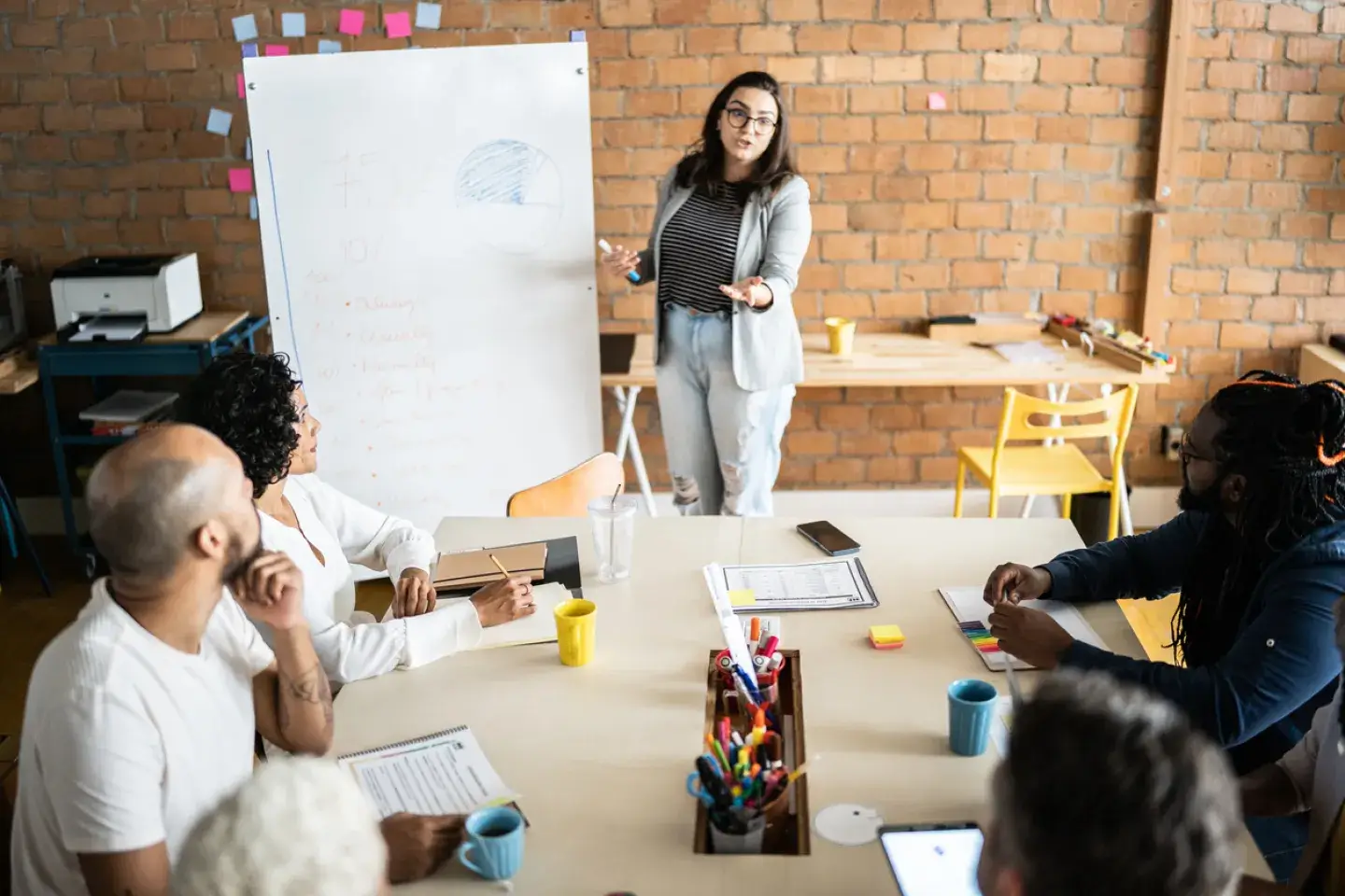Young woman doing a business presentation for coworkers in an office