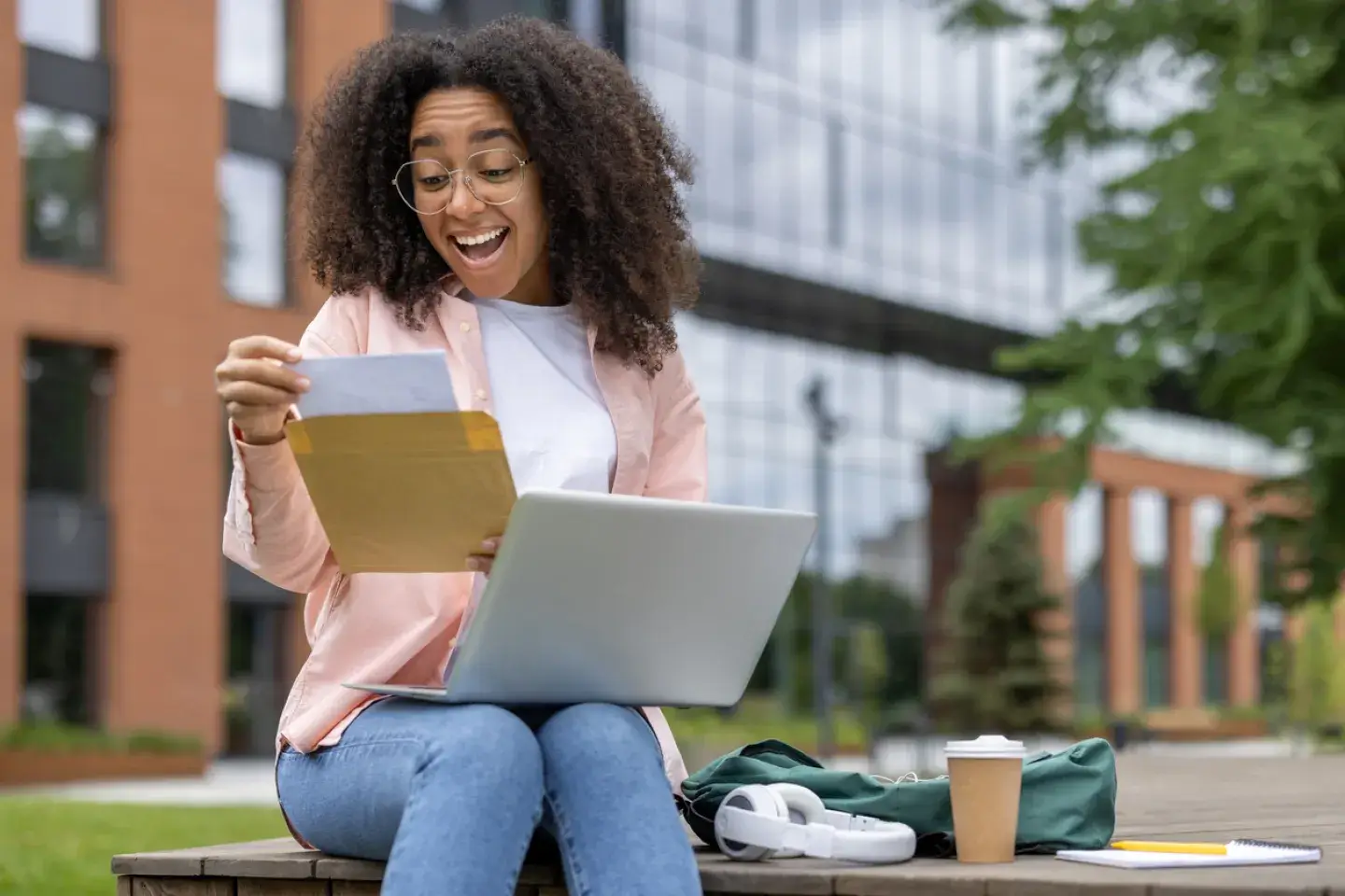 Excited student receiving letter of approval while studying on campus