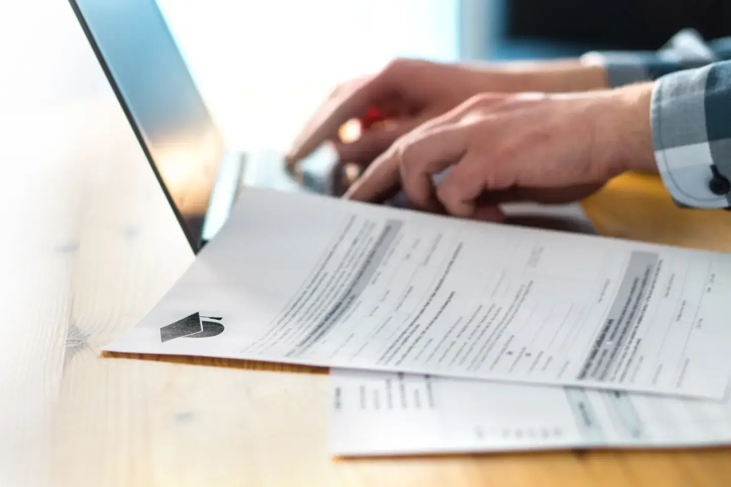 Young man writing college or university application form with laptop.
