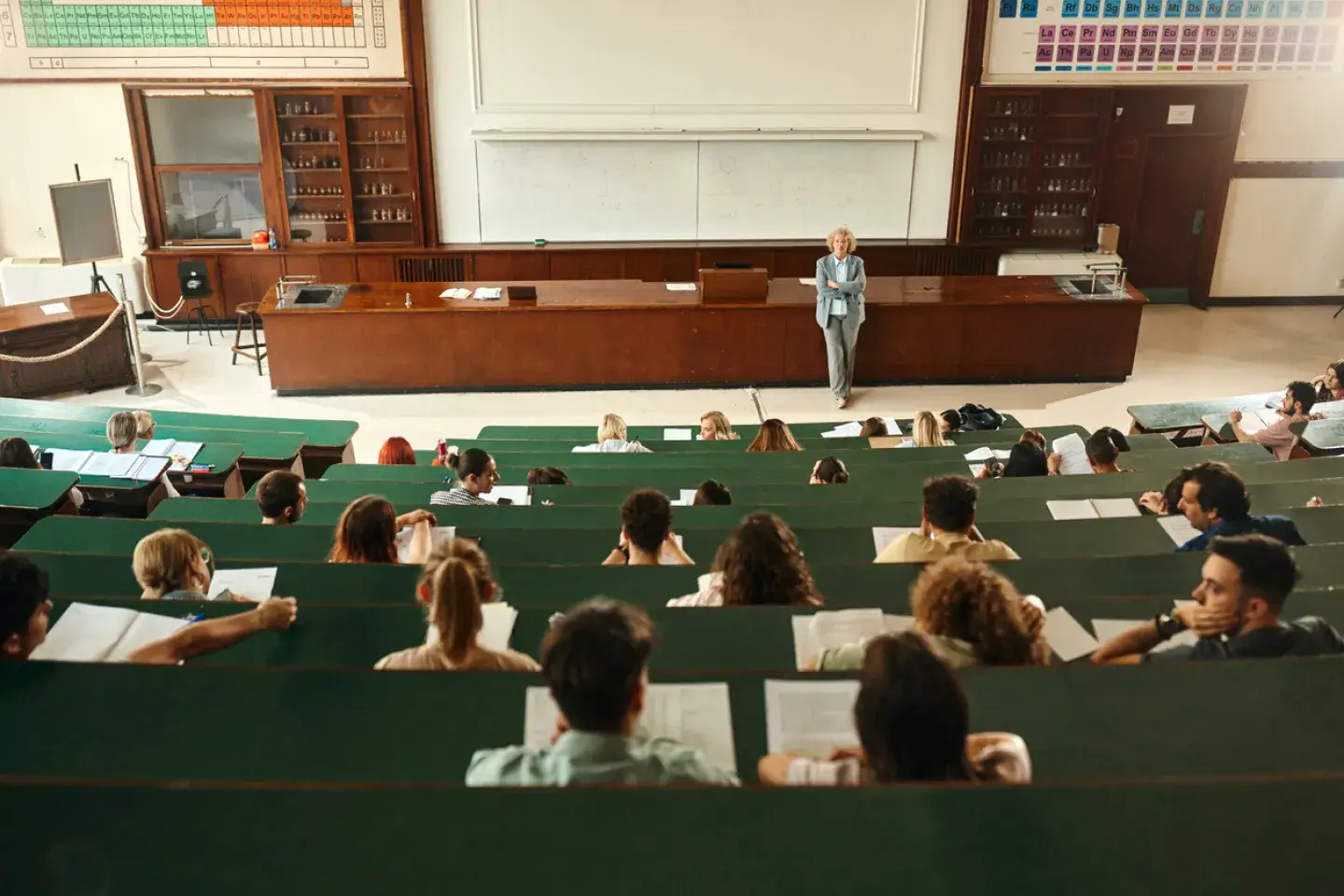 A professor stands at the front of an amphitheater.