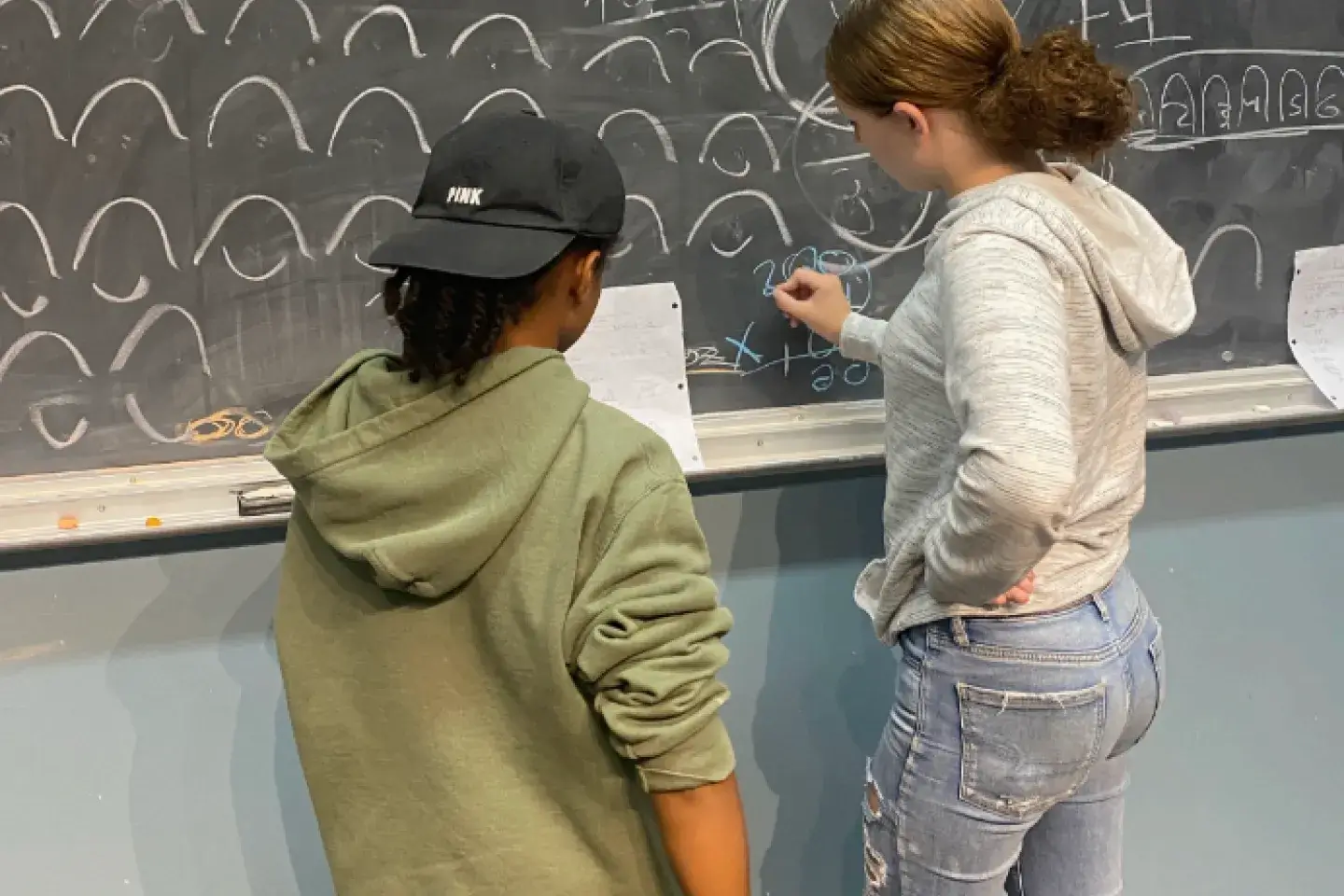 Two young students working on a chalkboard