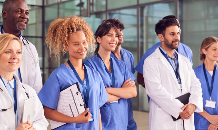 Smiling Medical Team Standing In Modern Hospital Building