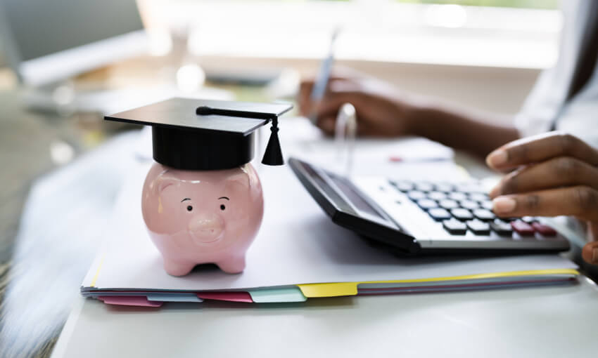 small piggybank with a college graduation cap on it 