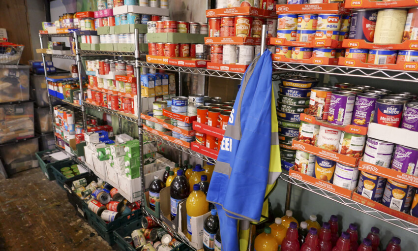 Food bank shelving filled with donated tinned food ready for distribution