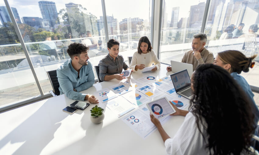 Multi racial group of people working with Paperwork on a board room table at a business presentation or seminar