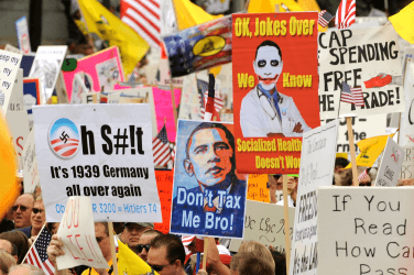 Reactionaries hold signs protesting President Barack Obama's health care legislation