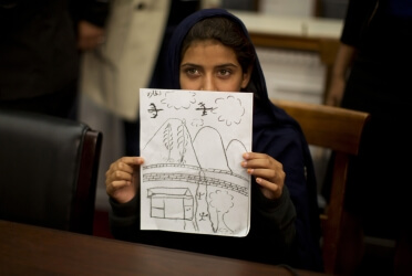 Pakistani girl shows drawing of a drone bombing