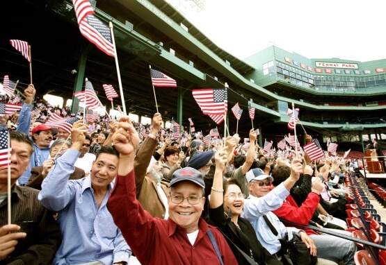 Immigrants cheer during naturalization ceremony at Fenway Park