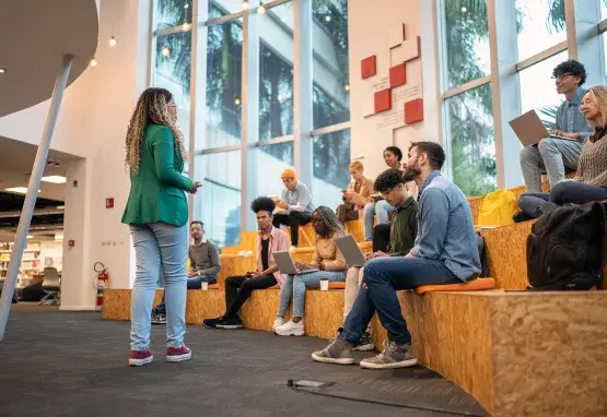 Woman engaging college students in an amphitheater seating arrangement.