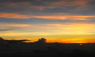 The Sun Descends into the Landscape with Orange Yellow and Bluegray Sky