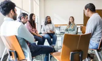 Small group discussion with people seated in chairs. 
