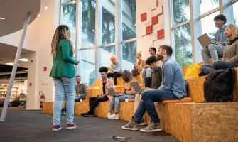 Woman engaging college students in an amphitheater seating arrangement.