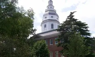 Maryland State House with trees in foreground. 