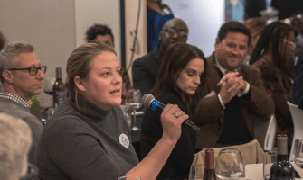 Seated woman speaks into microphone at event about democracy in Lexington, Kentucky