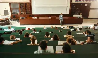 A professor stands at the front of an amphitheater.