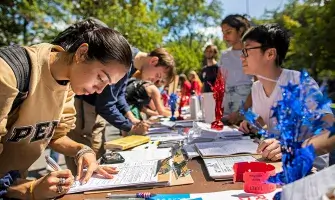 Students signing up for activities at an event at University of Pennsylvania. Photo by Eric Sucar.