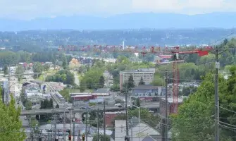 Photo of Tacoma Washington with city in foreground and mountains in the distance.